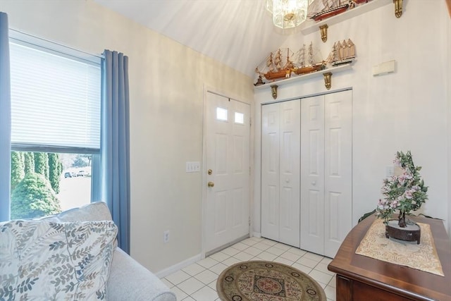 foyer featuring lofted ceiling, a notable chandelier, and light tile patterned floors