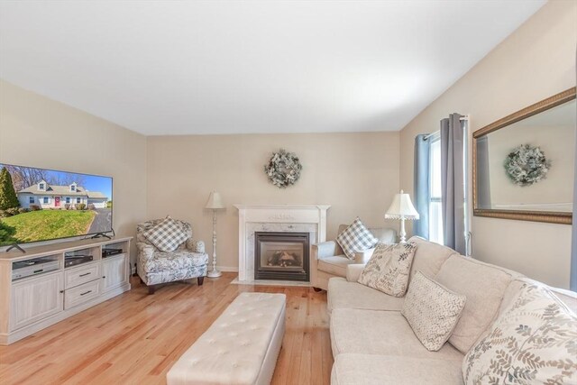 living room with a fireplace with flush hearth and light wood finished floors