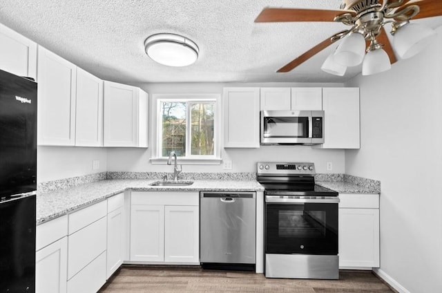 kitchen with white cabinets, appliances with stainless steel finishes, and sink