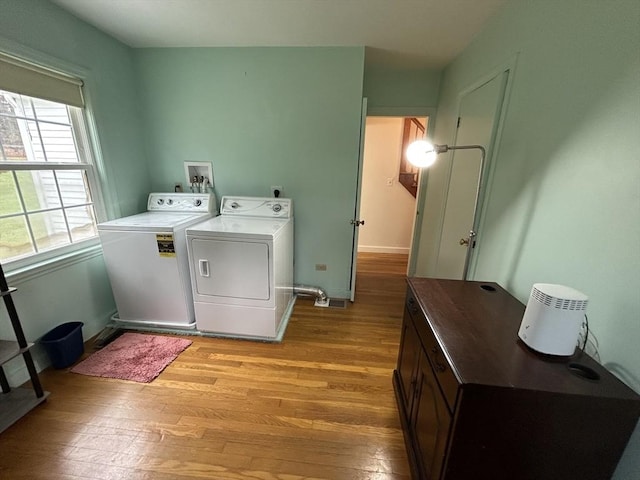 washroom featuring baseboards, laundry area, washing machine and dryer, and light wood finished floors