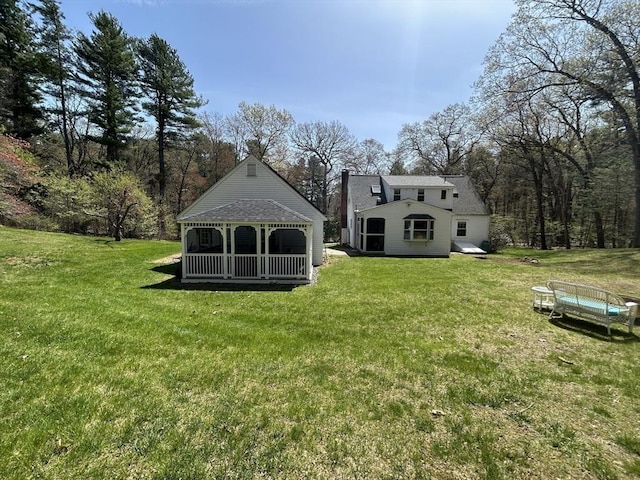 rear view of property with a lawn and a shingled roof