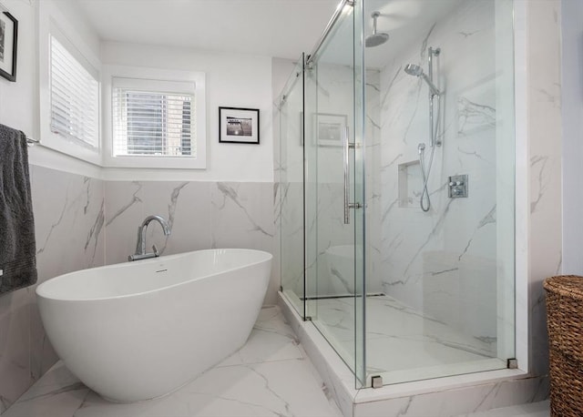 bathroom featuring a soaking tub, marble finish floor, and a marble finish shower