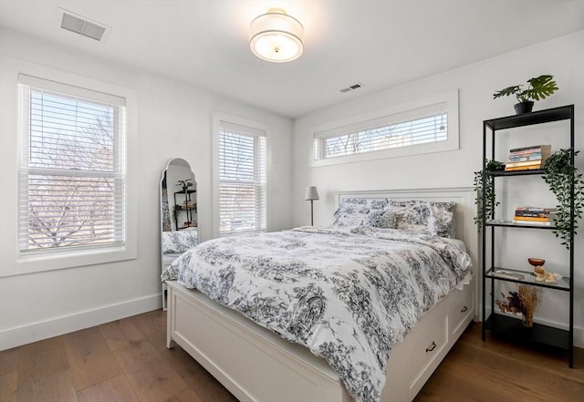 bedroom with visible vents, dark wood-type flooring, and baseboards