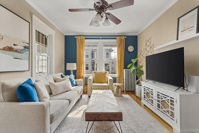 living area with light wood-style flooring, radiator, a ceiling fan, and a wealth of natural light