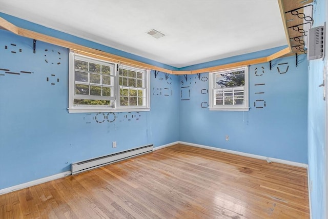 36 Fontaine St, Marlborough, MA 01752 - spare room featuring a baseboard heating unit, wood finished floors, and plenty of natural light