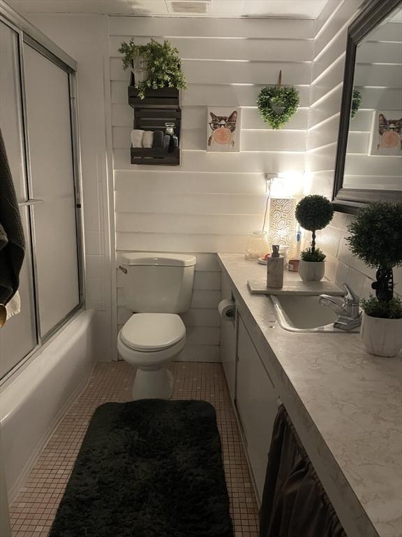 57 Broadlawn Park Unit 24, Boston, MA 02467 - bathroom featuring vanity, toilet, enclosed tub / shower combo, and tile patterned floors