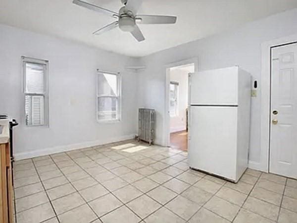 8 Hall Ave Unit 2, Braintree, MA 02184 - kitchen with freestanding refrigerator, radiator heating unit, ceiling fan, and light tile patterned floors