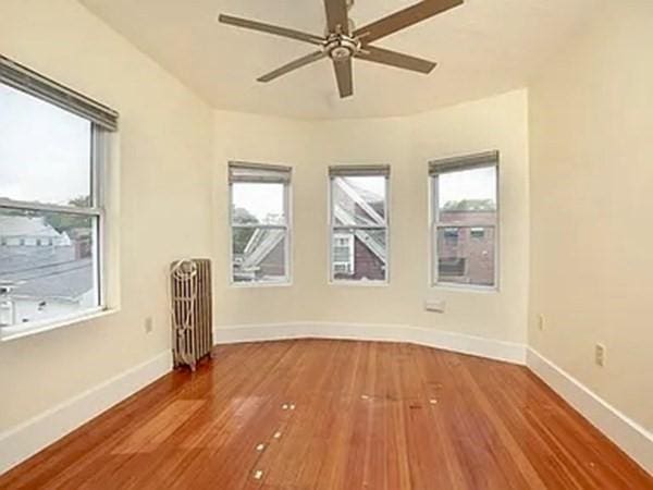8 Hall Ave Unit 2, Braintree, MA 02184 - empty room with radiator, wood finished floors, baseboards, and ceiling fan