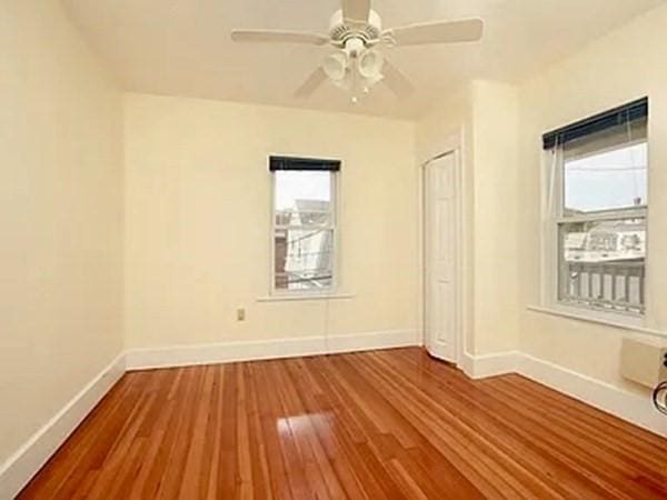 8 Hall Ave Unit 2, Braintree, MA 02184 - empty room featuring healthy amount of natural light, wood finished floors, baseboards, and ceiling fan