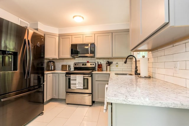 66 Captain Cook Ln Unit 66, Barnstable, MA 02632 - kitchen with appliances with stainless steel finishes, a sink, backsplash, gray cabinetry, and light tile patterned floors