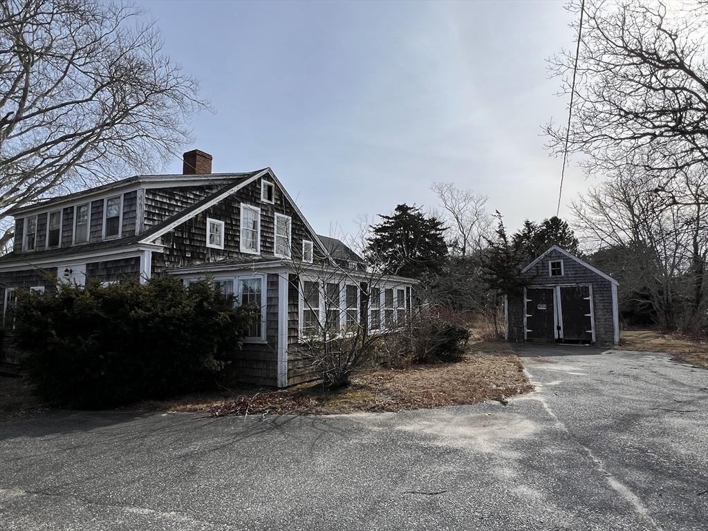view of home's exterior with a chimney and an outdoor structure