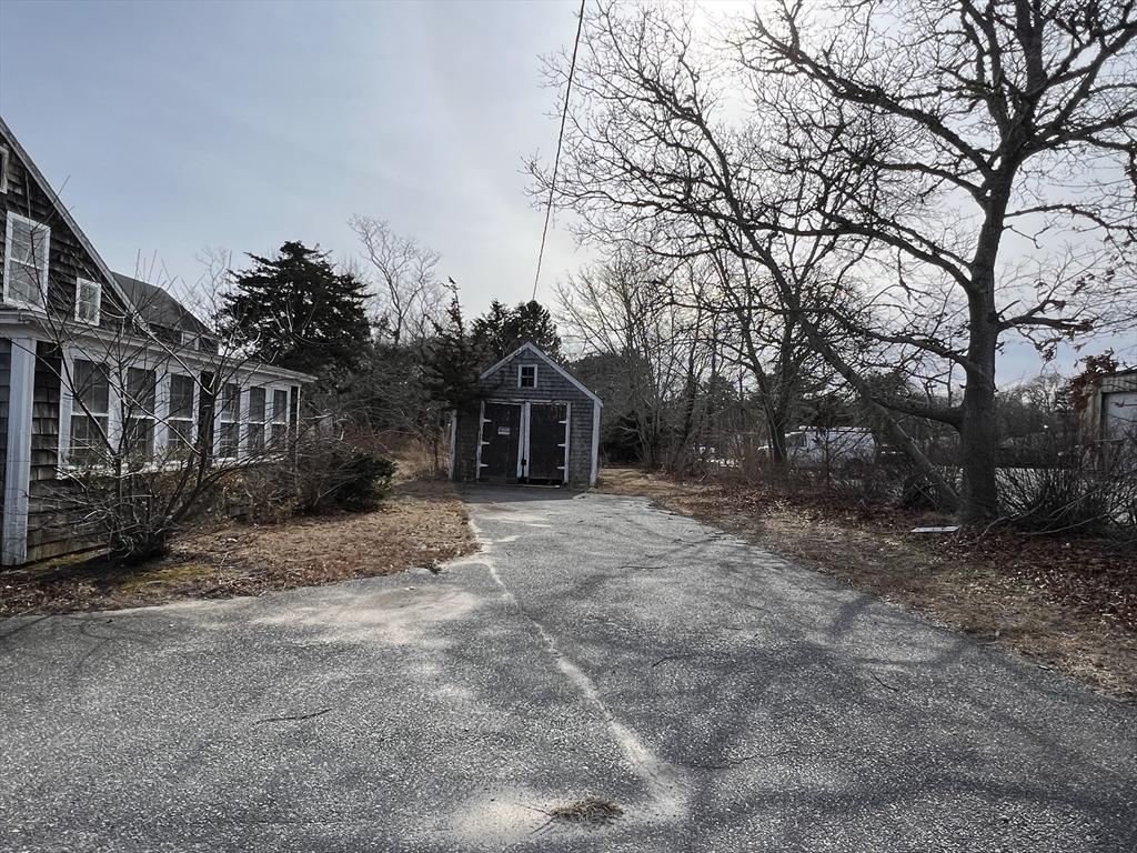 view of yard featuring an outbuilding, a shed, and asphalt driveway