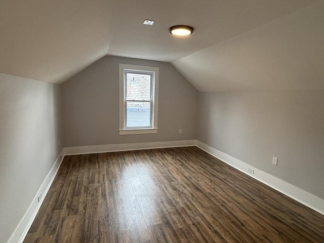 bonus room featuring vaulted ceiling, dark wood finished floors, and baseboards