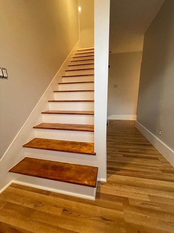 stairway featuring baseboards and wood finished floors