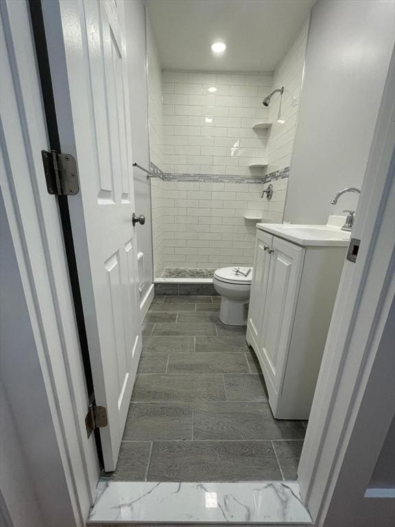 full bathroom featuring wood finish floors, recessed lighting, toilet, a stall shower, and vanity