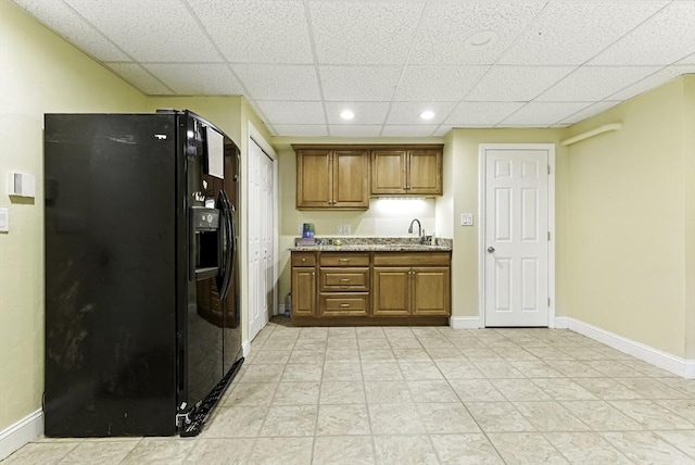 26 Waterville Ln, Shrewsbury, MA 01545 - kitchen featuring black fridge with ice dispenser, brown cabinetry, a drop ceiling, recessed lighting, and baseboards