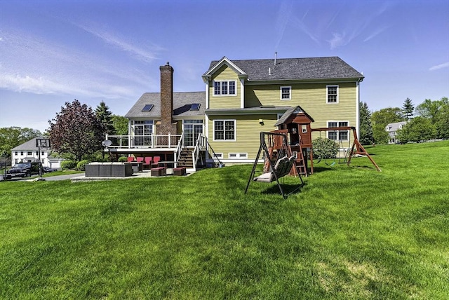 26 Waterville Ln, Shrewsbury, MA 01545 - back of property featuring a lawn, a wooden deck, a playground, a chimney, and an outdoor hangout area