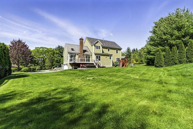 26 Waterville Ln, Shrewsbury, MA 01545 - back of property with a playground, a lawn, a chimney, and a wooden deck