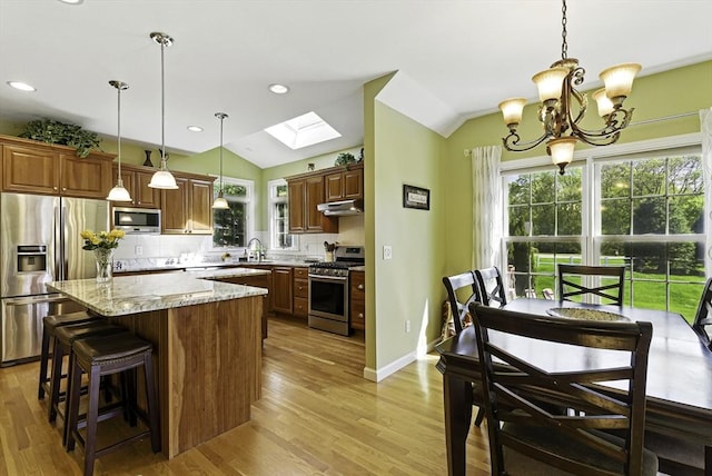 26 Waterville Ln, Shrewsbury, MA 01545 - kitchen with stainless steel appliances, under cabinet range hood, vaulted ceiling, backsplash, and a chandelier