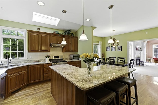26 Waterville Ln, Shrewsbury, MA 01545 - kitchen with a sink, a skylight, under cabinet range hood, stainless steel appliances, and a kitchen bar