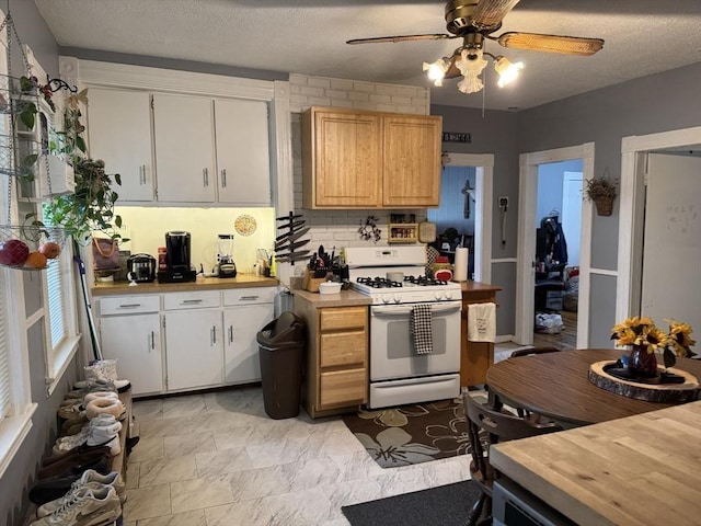 348 Fairmount St, Fitchburg, MA 01420 - kitchen featuring white gas range, ceiling fan, a textured ceiling, and white cabinets