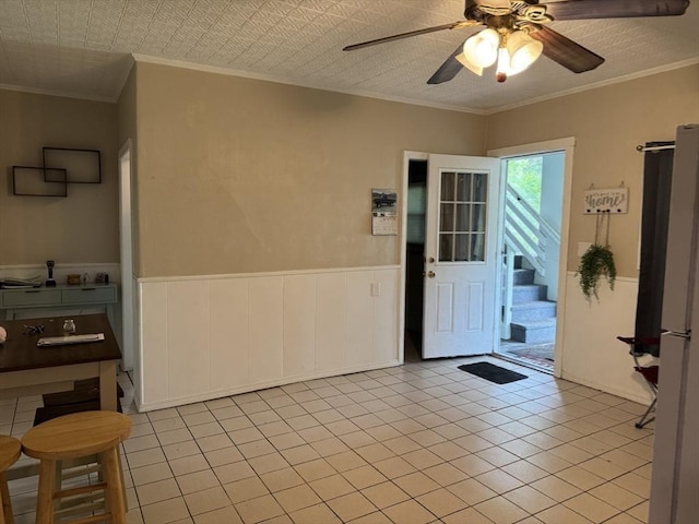 348 Fairmount St, Fitchburg, MA 01420 - entrance foyer with crown molding, a ceiling fan, a wainscoted wall, tile patterned floors, and stairway