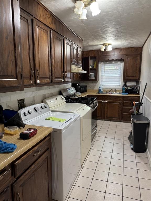 348 Fairmount St, Fitchburg, MA 01420 - washroom featuring washer and dryer, light tile patterned flooring, a chandelier, and wood walls