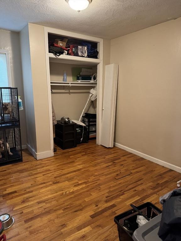 348 Fairmount St, Fitchburg, MA 01420 - bedroom featuring wood finished floors, a textured ceiling, a closet, and baseboards
