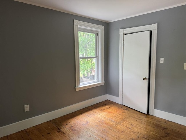 348 Fairmount St, Fitchburg, MA 01420 - unfurnished bedroom with baseboards, light wood finished floors, ornamental molding, and a closet