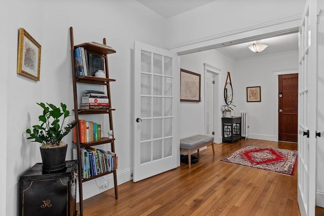 hall with wood-type flooring and baseboards