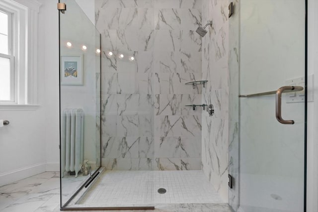 full bath with a marble finish shower, radiator heating unit, marble finish floors, and baseboards