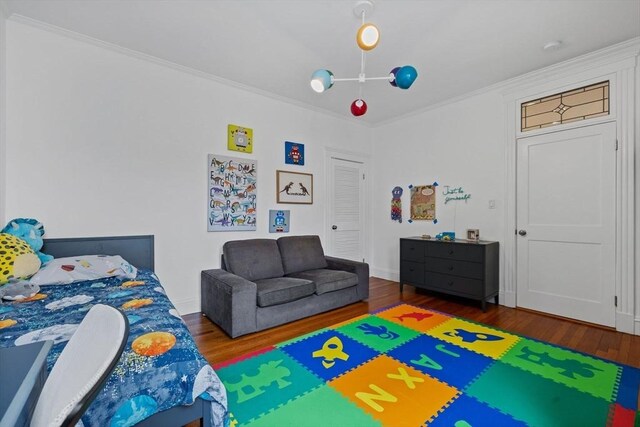 bedroom featuring wood finished floors and ornamental molding