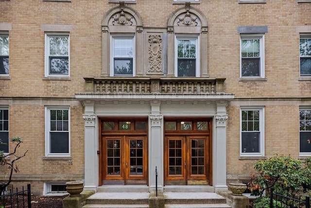 doorway to property featuring brick siding and french doors