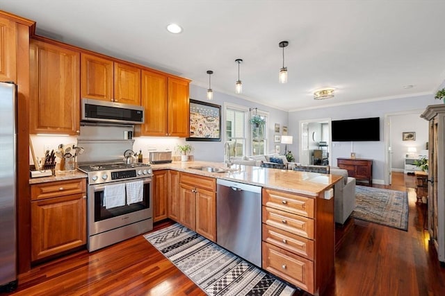 kitchen featuring appliances with stainless steel finishes, kitchen peninsula, sink, and hanging light fixtures