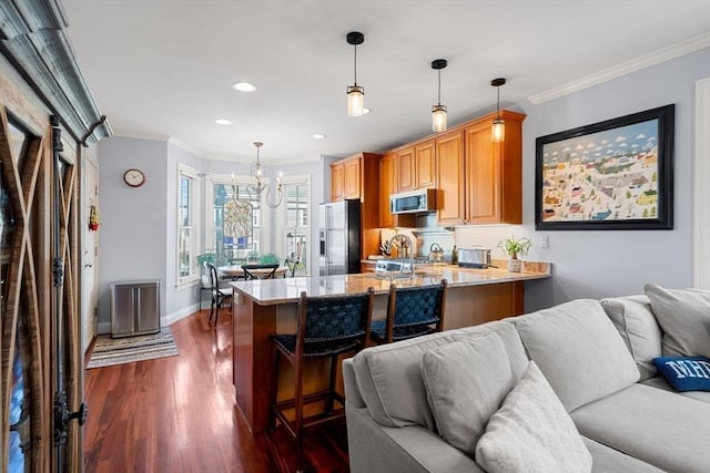 kitchen with a breakfast bar, stainless steel appliances, light stone counters, dark hardwood / wood-style flooring, and kitchen peninsula