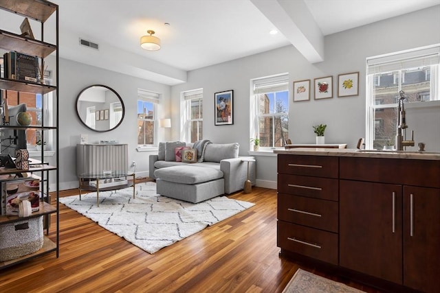 living area featuring dark wood-type flooring, recessed lighting, visible vents, and baseboards