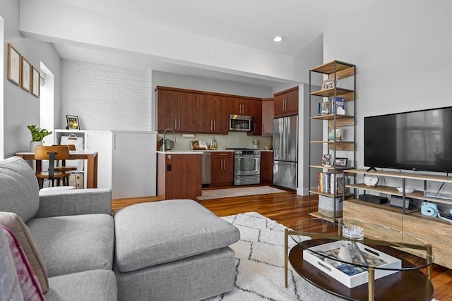 living room with dark wood-style floors and recessed lighting