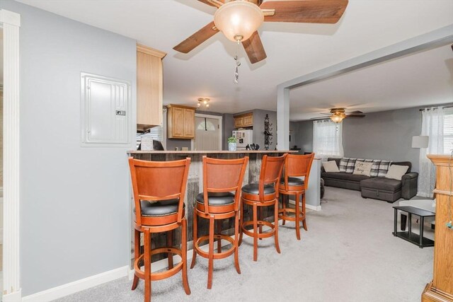 20 Wilcox St, Fall River, MA 02724 - kitchen with ceiling fan, freestanding refrigerator, light carpet, a kitchen bar, and baseboards