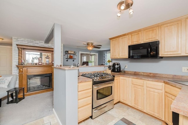 20 Wilcox St, Fall River, MA 02724 - kitchen with black microwave, stainless steel gas range, light brown cabinets, a peninsula, and a glass covered fireplace