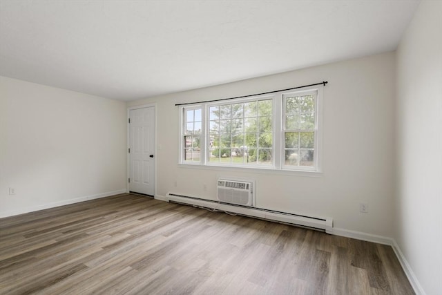 20 Washington St Unit 15, Easton, MA 02356 - empty room featuring wood finished floors, baseboard heating, baseboards, and an AC wall unit