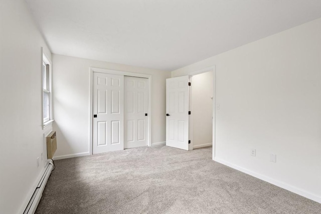 20 Washington St Unit 15, Easton, MA 02356 - unfurnished bedroom featuring a baseboard radiator, carpet, baseboards, and a closet