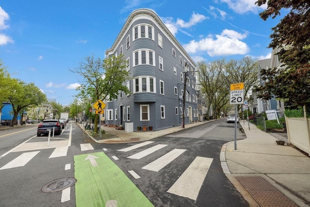 view of asphalt street featuring traffic signs, sidewalks, and curbs