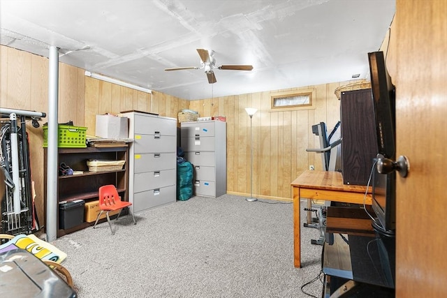 interior space featuring ceiling fan, light colored carpet, and wood walls