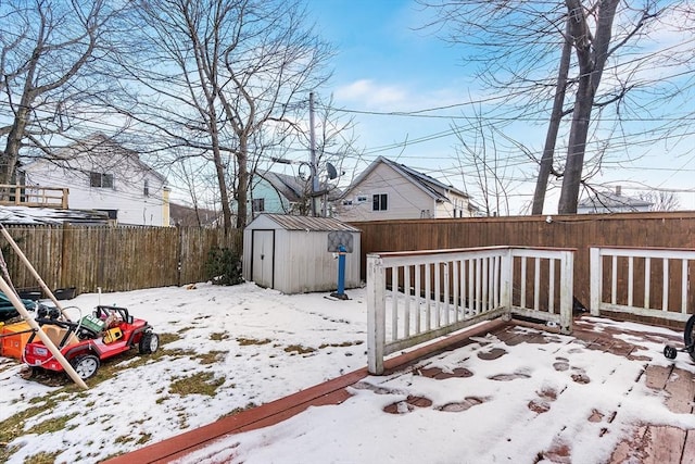 snow covered deck with a storage shed