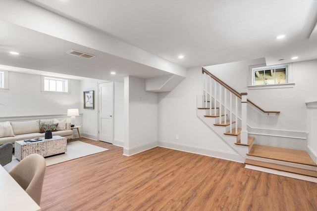 living area with recessed lighting, wood finished floors, visible vents, and baseboards