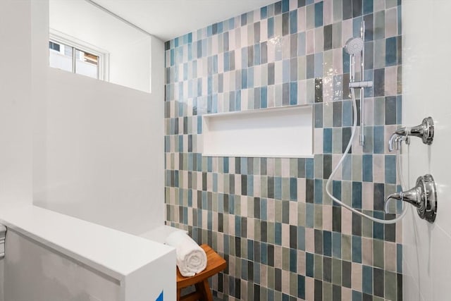 bathroom with tiled shower and tile walls