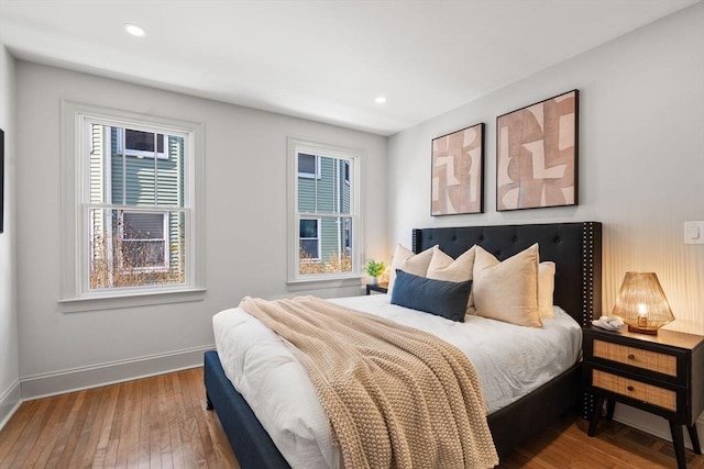 bedroom with hardwood / wood-style floors, recessed lighting, and baseboards