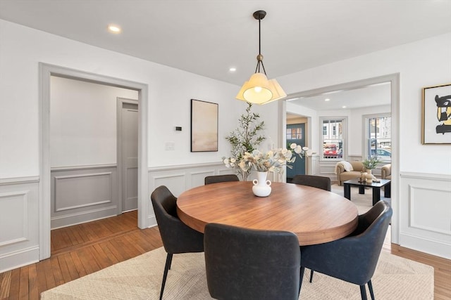 dining space with a wainscoted wall, recessed lighting, and light wood-style floors