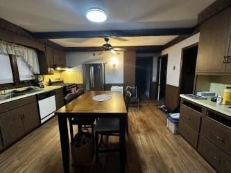 kitchen featuring dark brown cabinetry, hardwood / wood-style flooring, ceiling fan, stainless steel appliances, and beam ceiling