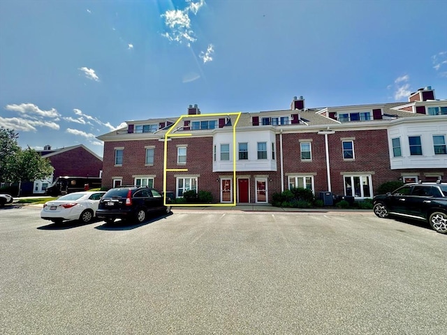 158 Quincy Shore Dr Unit 78, Quincy, MA 02171 - view of property with uncovered parking, a chimney, and brick siding